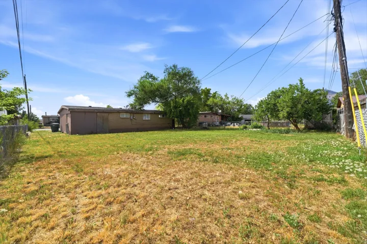 Expansive outdoor space featuring a combination of green grass and dry patches