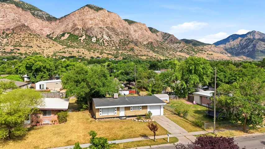 Ranch-style residence featuring a prominent mountain backdrop, attached garage, and a concrete driveway