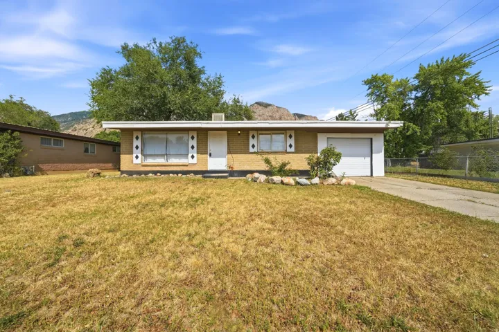 Brick exterior with a flat roofline, integrated garage, and a concrete driveway
