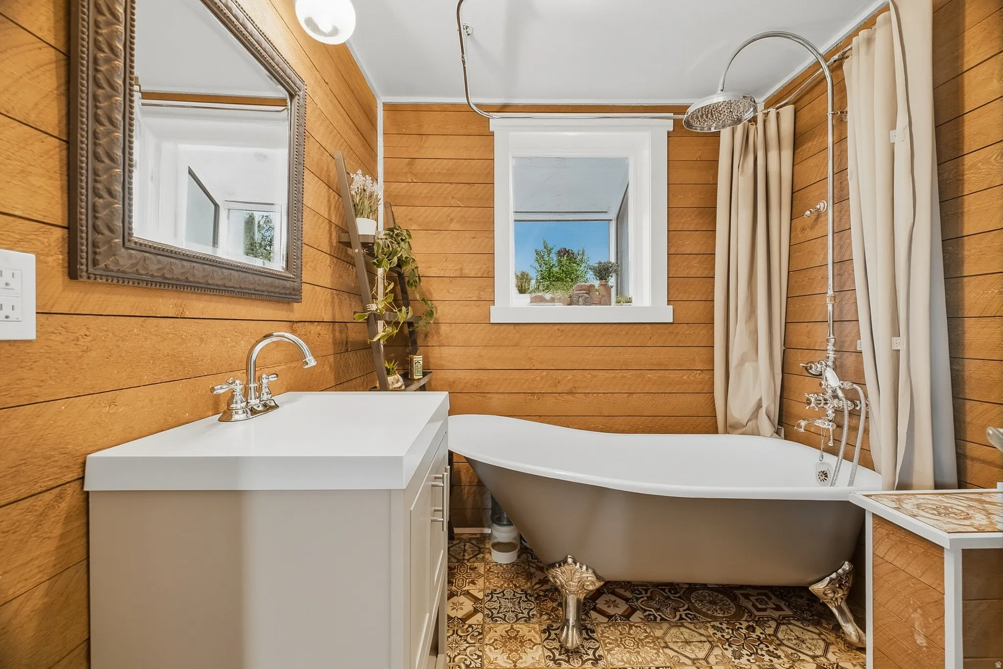 Bathroom featuring wood plank walls, a freestanding clawfoot bathtub with a rain showerhead, a single-sink vanity with a white countertop, and patterned floor tile