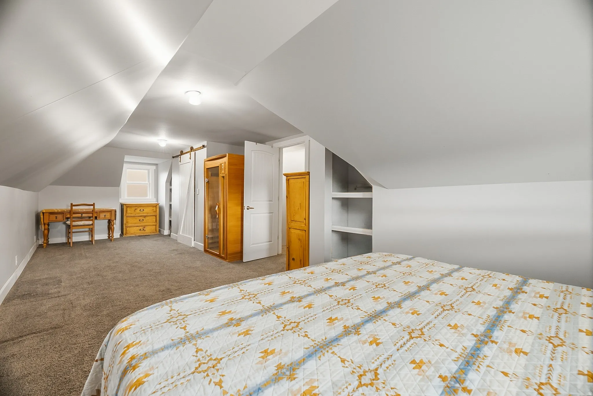 Carpeted room with sloped ceilings and recessed lighting