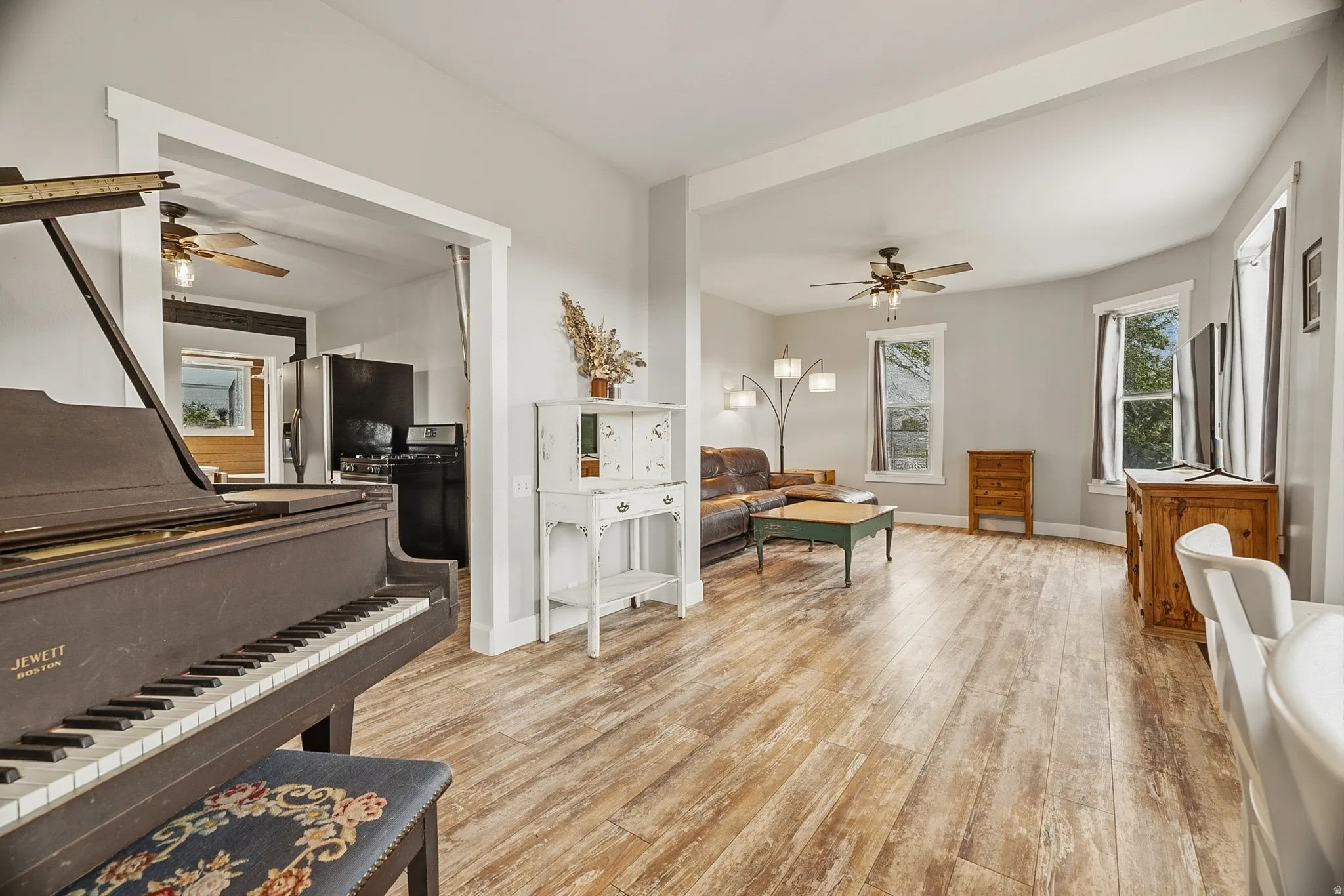 Open-concept living area featuring wood-finish flooring, light gray walls, and white trim