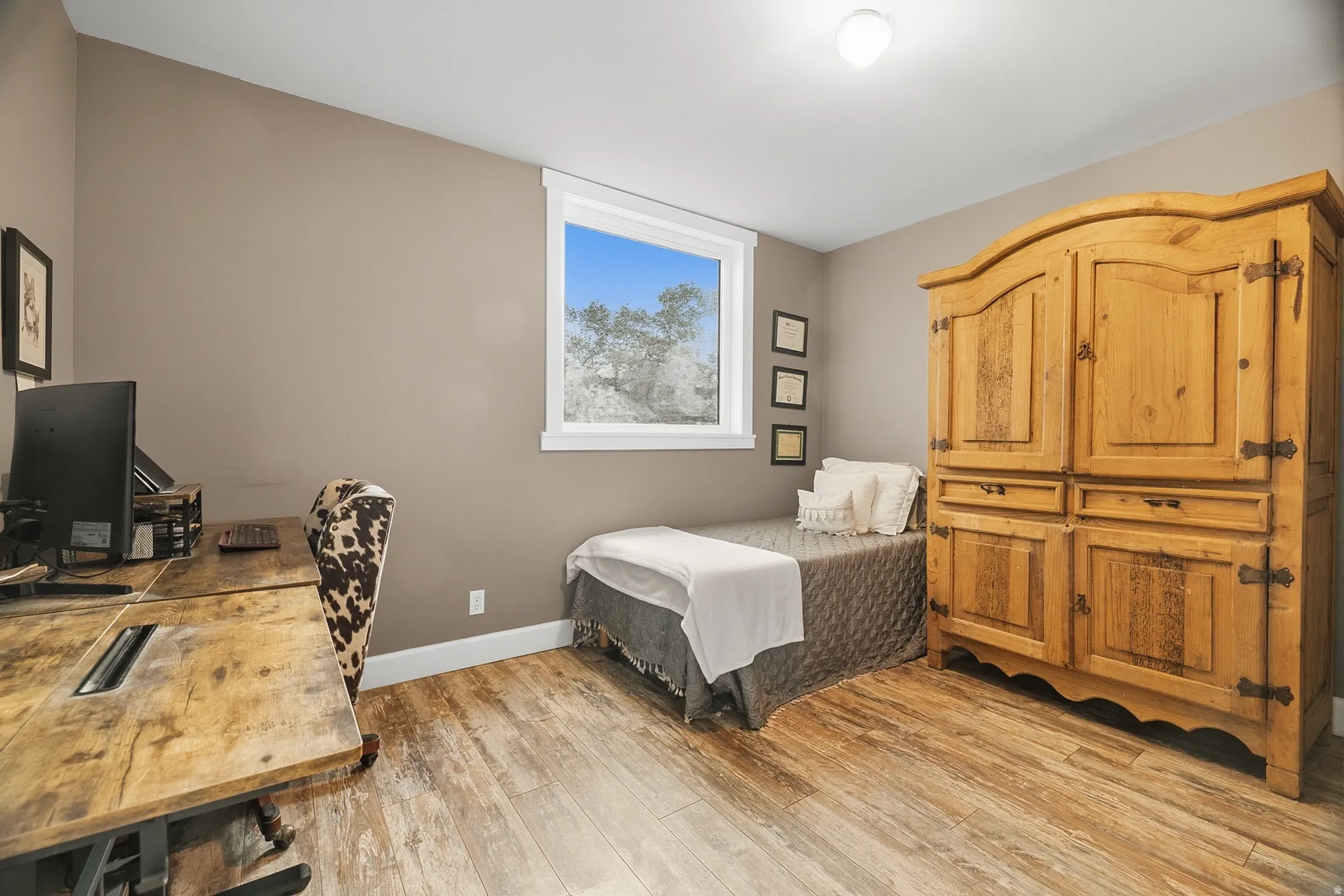 Room featuring wood-finish flooring, neutral wall tones, and white trim