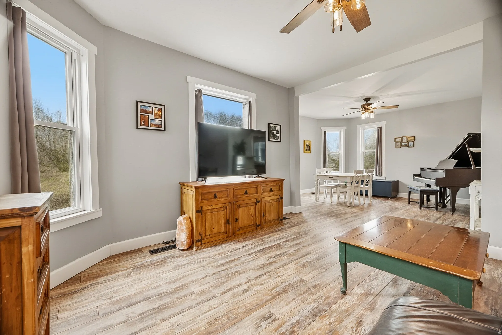 Light gray walls and wood-finish flooring characterize this open living space