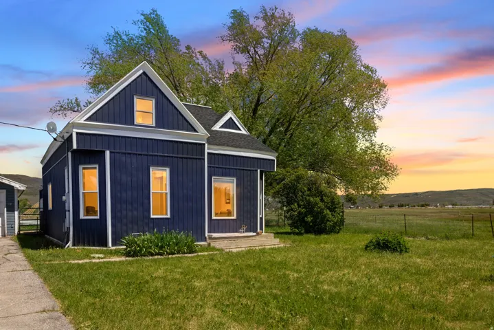 Dark blue vertical siding exterior with white trim accents and a gable roofline