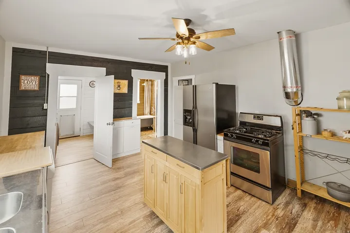 Kitchen featuring wood-finish flooring and a ceiling fan