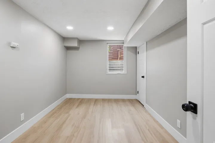 Room featuring neutral painted walls, light wood-finish flooring, recessed lighting, and white baseboards