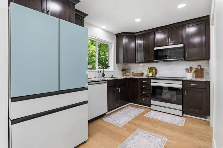 Main Kitchen featuring dark wood cabinetry, light wood-finish flooring, and white subway tile backsplash