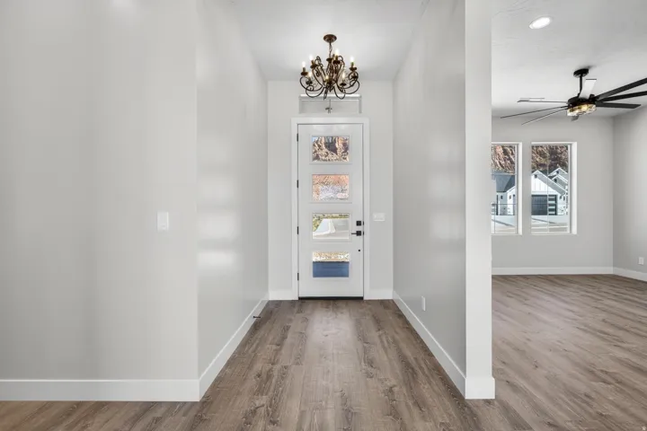 Entryway with wood-finish flooring and a decorative chandelier