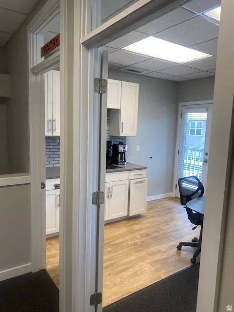 Functional pantry space featuring white cabinetry, grey countertops, and subway tile backsplash