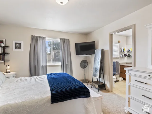 Windowed bedroom featuring neutral wall tones and carpeted flooring