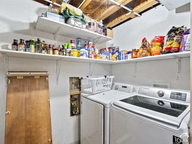 Dedicated laundry area featuring a white washing machine, white dryer, and integrated wall shelving