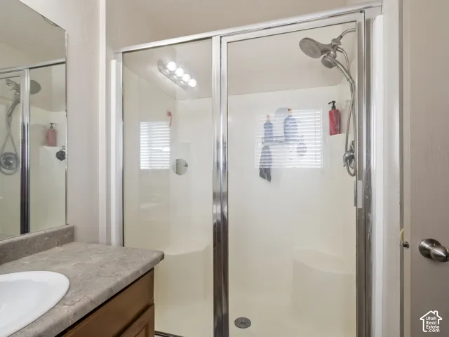 Glass-enclosed shower with a built-in seat, featuring a dual showerhead system