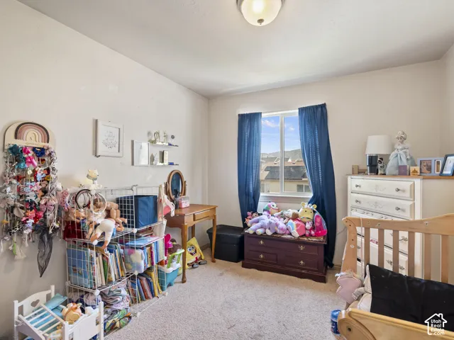 Carpeted room featuring a window with blue drapes, offering exterior views