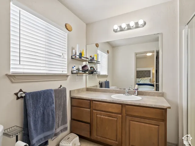 Bathroom vanity featuring a single basin sink, laminate countertop, and wood-finish cabinetry