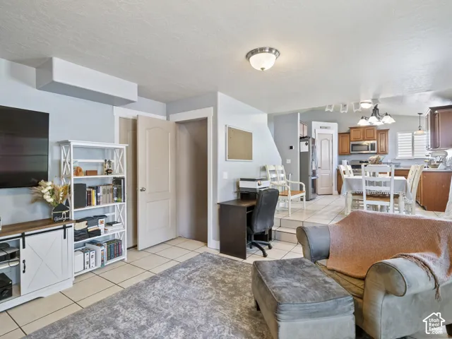Open-concept living space featuring light-colored wall paint and tile flooring