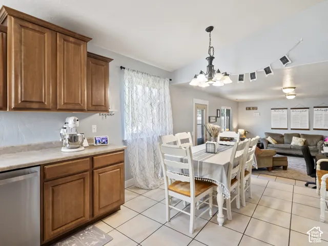 Dining area featuring a chandelier, tile flooring, and a window with sheer curtains