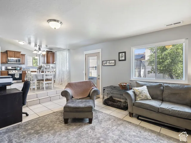 Open-concept living space featuring light tile flooring and a large window