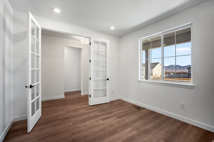Room featuring wood-finish flooring, recessed lighting, and a large window with mountain scenery