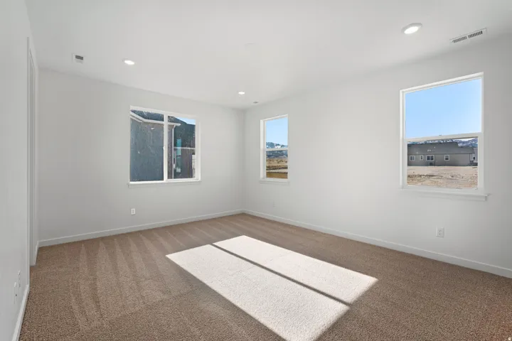 Bright interior space featuring light beige carpet