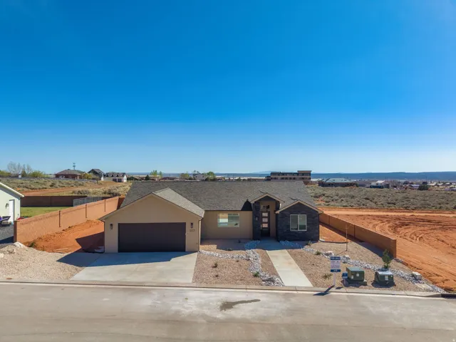 Contemporary single-story residence featuring a two-car garage, partial stone facade, and a concrete driveway