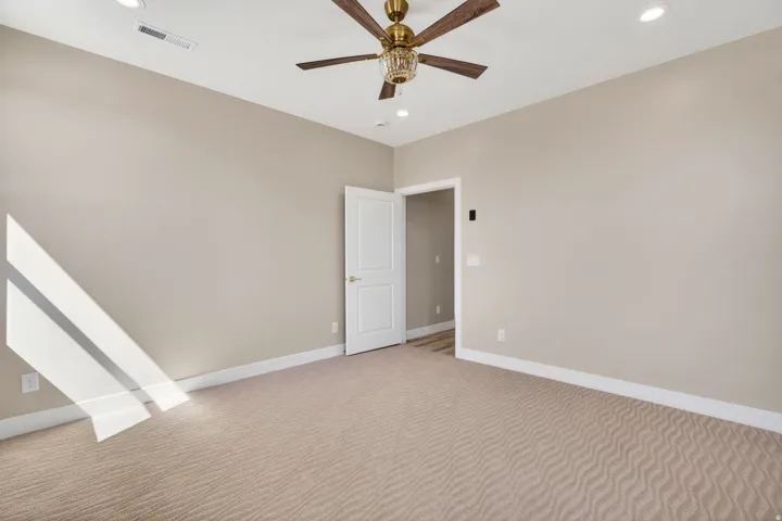 Neutral-toned walls and plush patterned carpeting define this interior space