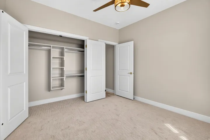 Room featuring light-toned carpeting, neutral wall color, and white baseboards