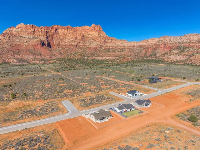 Expansive desert landscape featuring red rock mountains and new residential construction
