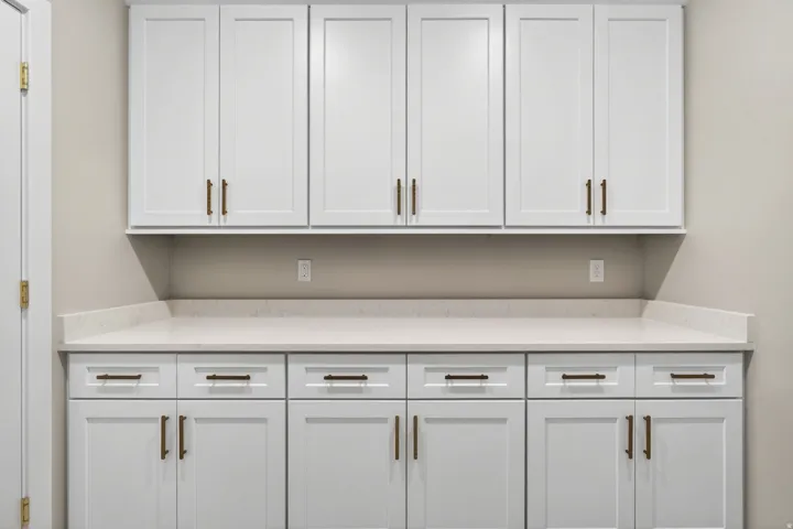 White cabinetry featuring Shaker-style doors and bronze hardware