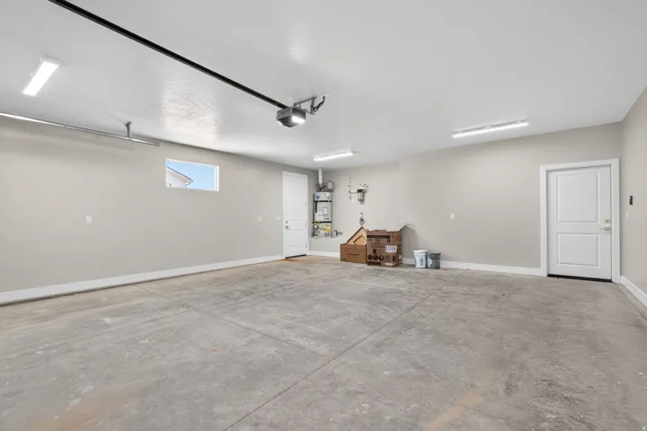 Spacious garage with concrete flooring, neutral wall tones, and overhead strip lighting