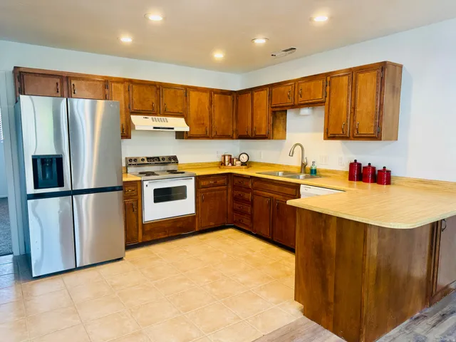 Kitchen featuring warm wood cabinetry, light wood-finish countertops, and recessed ceiling lighting