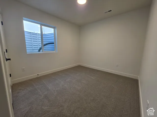Neutral-toned carpeting extends throughout this room, complemented by white walls and baseboards