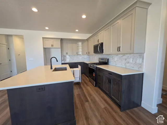 Modern kitchen featuring a spacious island with an undermount sink, quartz countertops, and two-tone cabinetry
