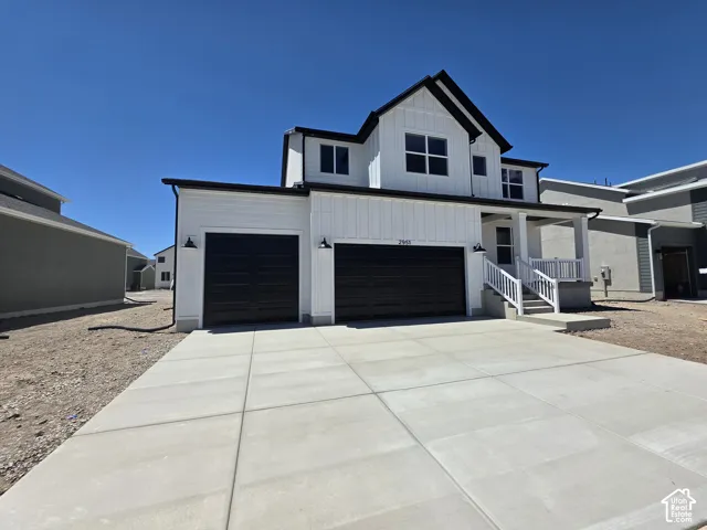 Modern farmhouse exterior featuring white board-and-batten siding with black trim accents