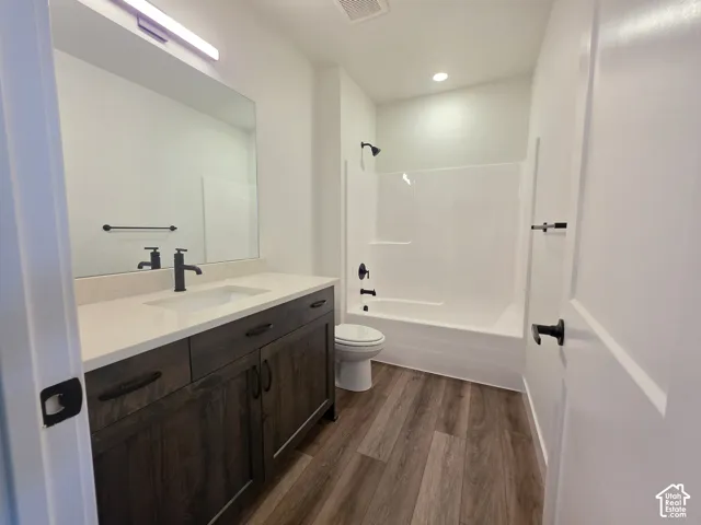 Bathroom featuring a dark wood-finish vanity with an undermount sink, light-toned countertop, and matte black fixtures