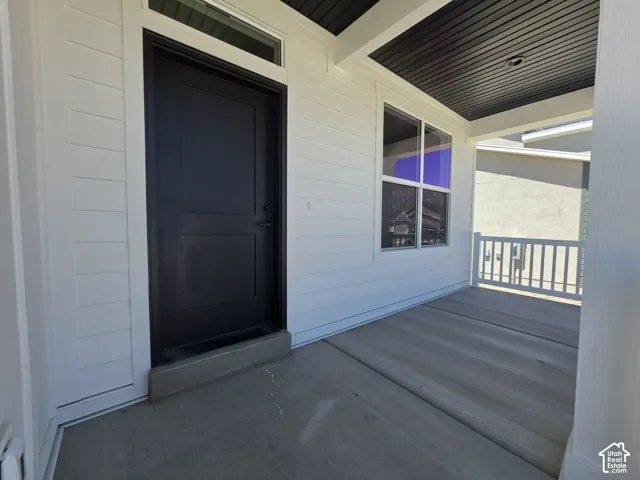 Inviting covered porch with concrete flooring and white railing