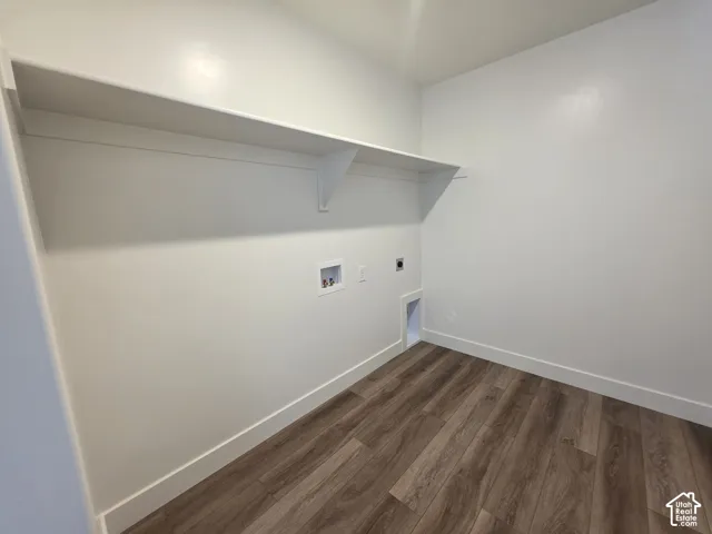 Laundry area featuring a built-in white shelf, wood-finish flooring, white baseboards, and appliance hookups