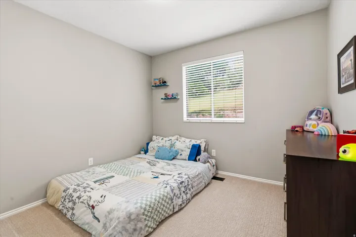 Room with light neutral walls, a single window with horizontal blinds, and beige carpet flooring