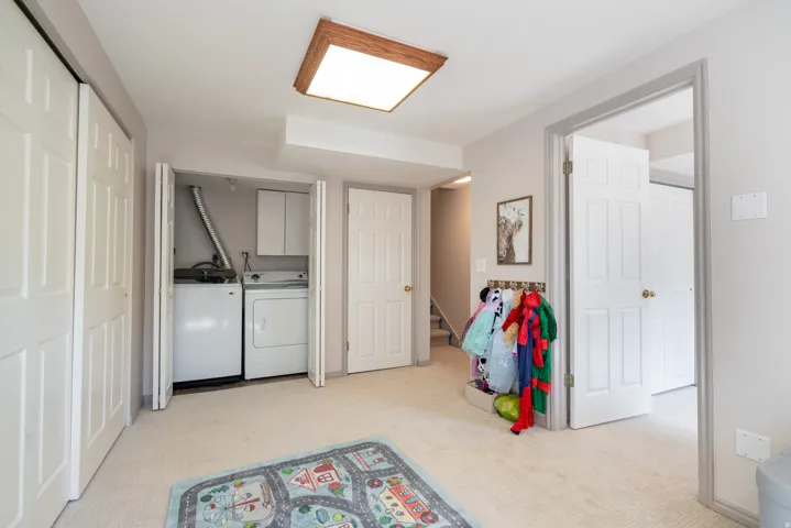 Recessed laundry closet with washer and dryer, adjacent built-in cabinetry, and overhead lighting