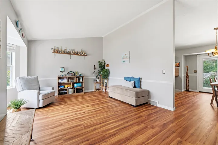 Large living room with vaulted ceiling and perfect entertaining space and access to kitchen.