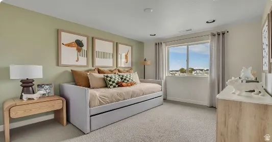 Spacious room featuring light green accent wall, neutral carpeting, recessed lighting, and a large window with neighborhood scenery. This home is To Be Built and the pictures are of a previous home