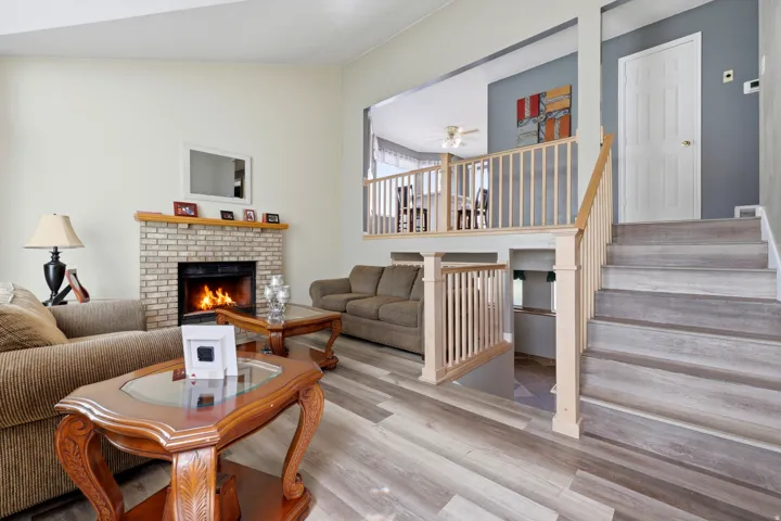 Living room featuring a brick-faced fireplace with a wood mantel