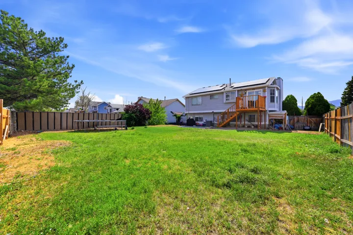 Expansive green lawn with a wooden privacy fence