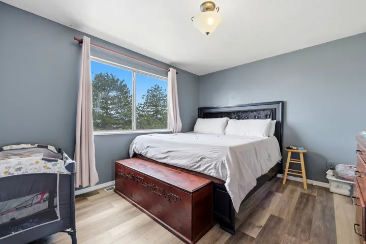 Spacious interior featuring wood-finish flooring, a broad window, and a ceiling-mounted light fixture
