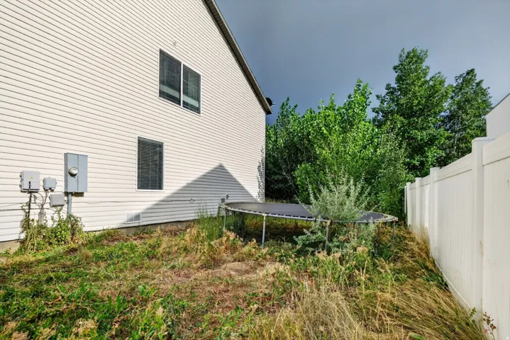 Side exterior featuring horizontal vinyl siding, dual windows, and an electrical meter