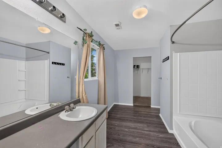 Bathroom featuring a vanity with an integrated sink, a rectangular mirror, and a window with natural light