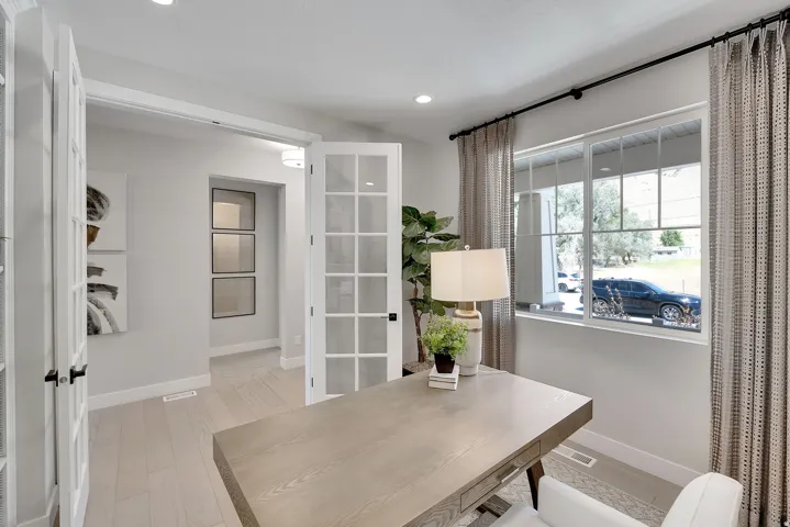 Home office featuring light wood-finish flooring, recessed lighting, and a large window with privacy blinds