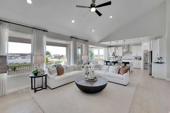 Vaulted ceilings highlight this expansive open-concept living space with recessed lighting and a ceiling fan