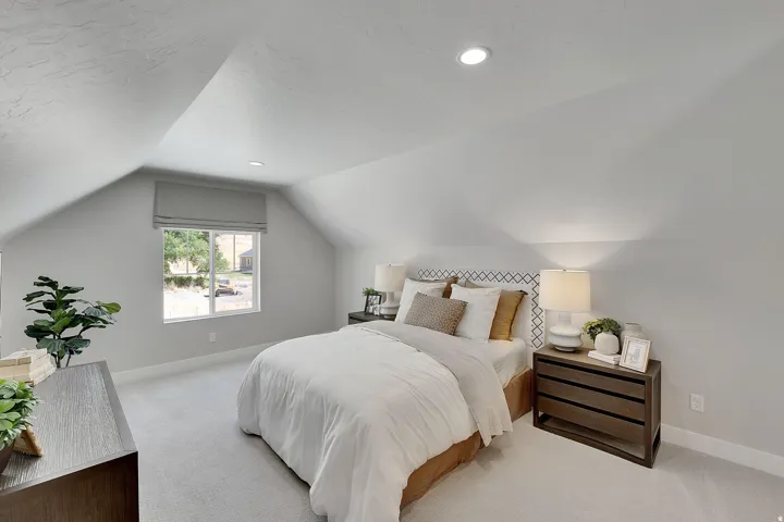 Attic room featuring a window with a roman shade, recessed lighting, and light-colored carpeting