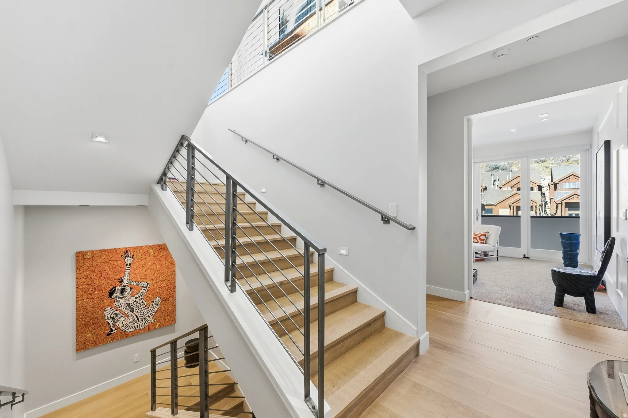 Modern staircase featuring wood treads, contemporary metal railings, and integrated wall lighting